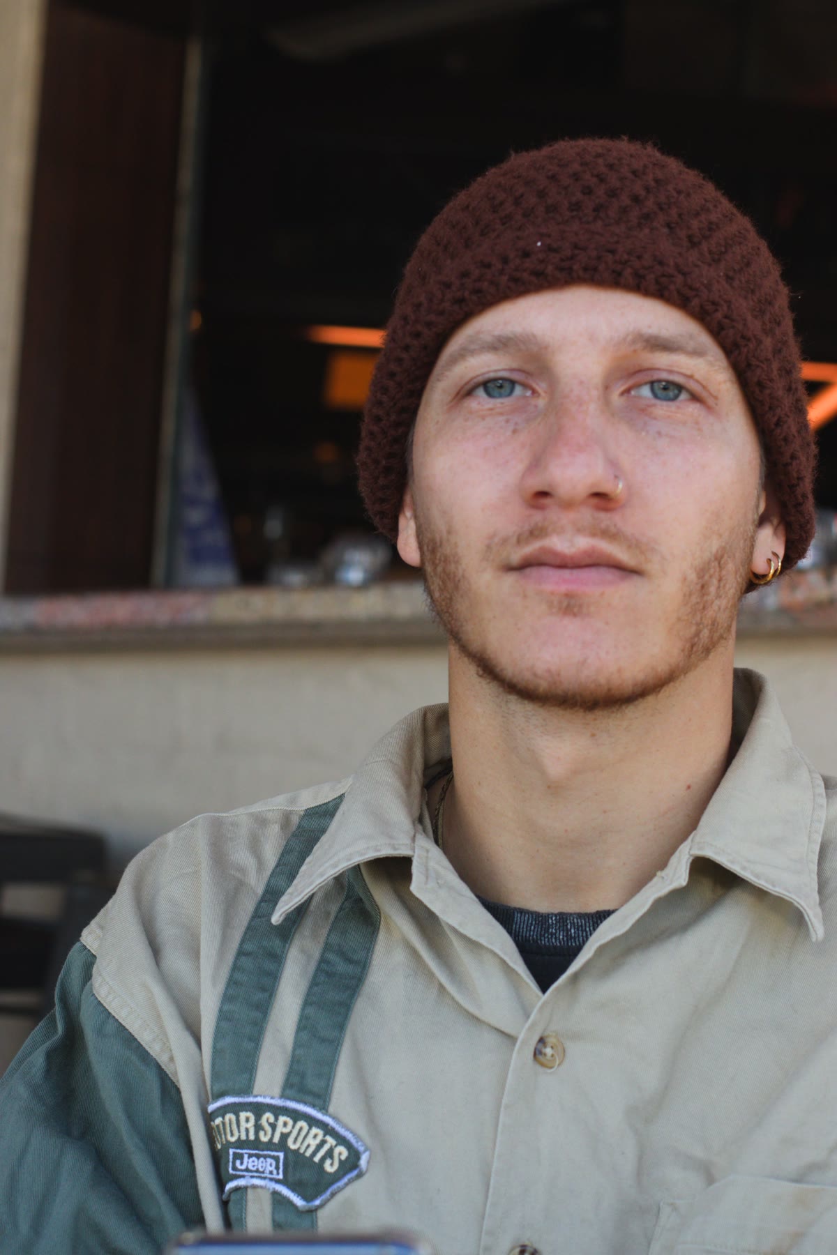 Portrait of Amnon in a knitted beanie, looking at the camera